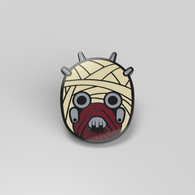 An officially licensed Star Wars enamel pin featuring a mummy face reminiscent of a Tusken Raider, called the Tusken Raider Mask Pin.