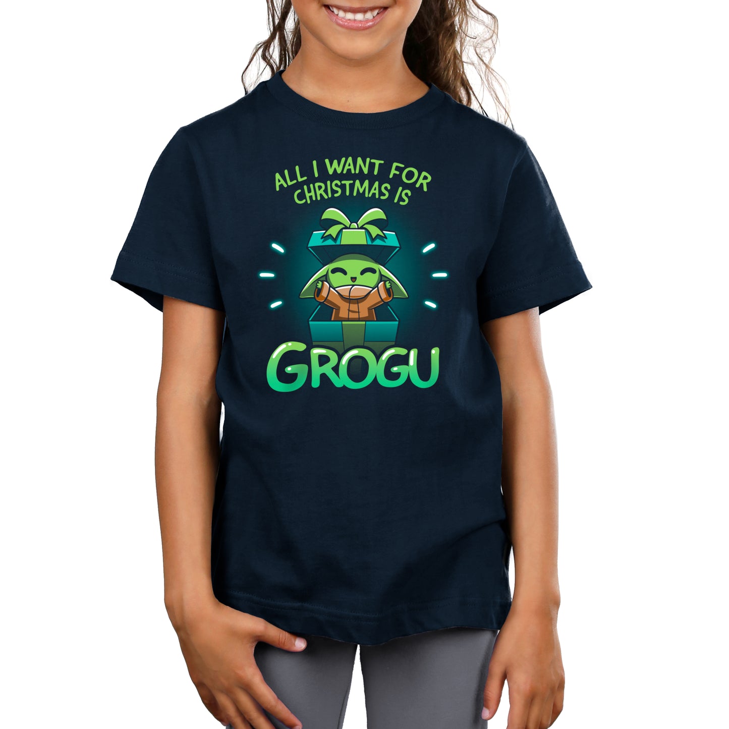 A girl proudly donning an officially licensed Star Wars t-shirt, expressing her holiday wish for All I Want For Christmas Is Grogu.
