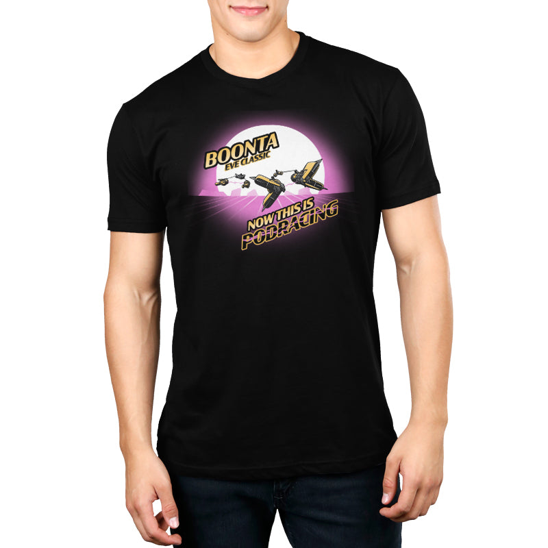 A man is wearing a black t-shirt featuring licensed Star Wars Boonta Eve Classic Podracing graphics.