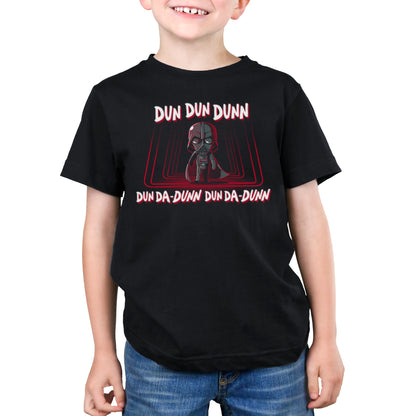 A young boy wearing an officially licensed Star Wars Darth Vader T-shirt in The Imperial March design.