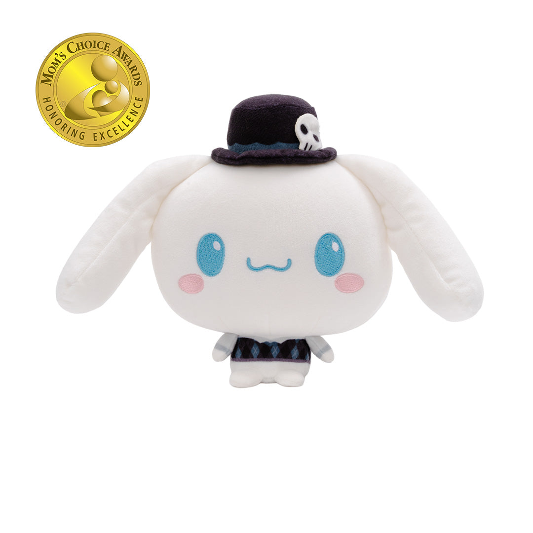 A Cinnamoroll Cloudheads plushie with long floppy ears, blue eyes, pink cheeks, and a small dark top hat with a skull detail, shown on a plain white background. A gold Mom's Choice Awards appears in the upper left corner.