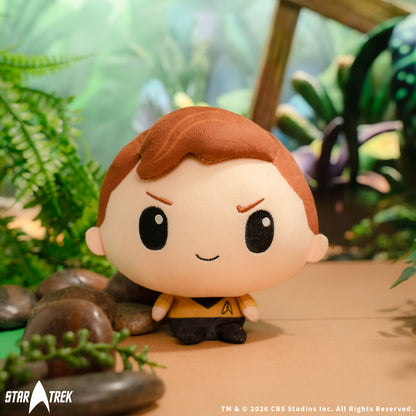 Star Trek Kirk Cloudheads plushie sitting near rocks and foliage