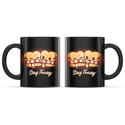 Ceramic Mug_TeeTurtle Stay Toasty Mug black mug featuring two smiling slices of toast wrapped together in a cozy striped scarf above the phrase "Stay Toasty."