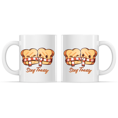 Ceramic Mug_TeeTurtle Stay Toasty Mug white mug featuring two smiling slices of toast wrapped together in a cozy striped scarf above the phrase "Stay Toasty."