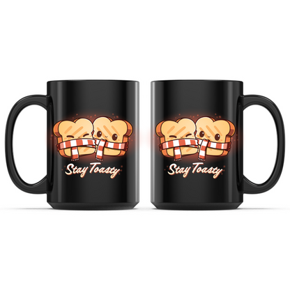 Ceramic Mug_TeeTurtle Stay Toasty Mug black mug featuring two smiling slices of toast wrapped together in a cozy striped scarf above the phrase "Stay Toasty."