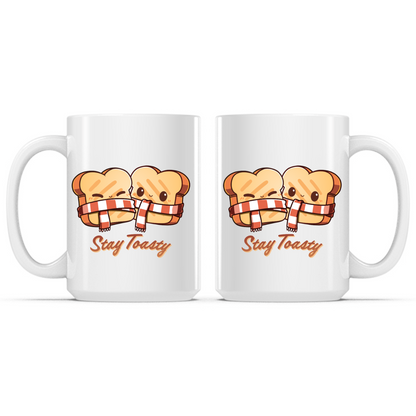 Ceramic Mug_TeeTurtle Stay Toasty Mug white mug featuring two smiling slices of toast wrapped together in a cozy striped scarf above the phrase "Stay Toasty."