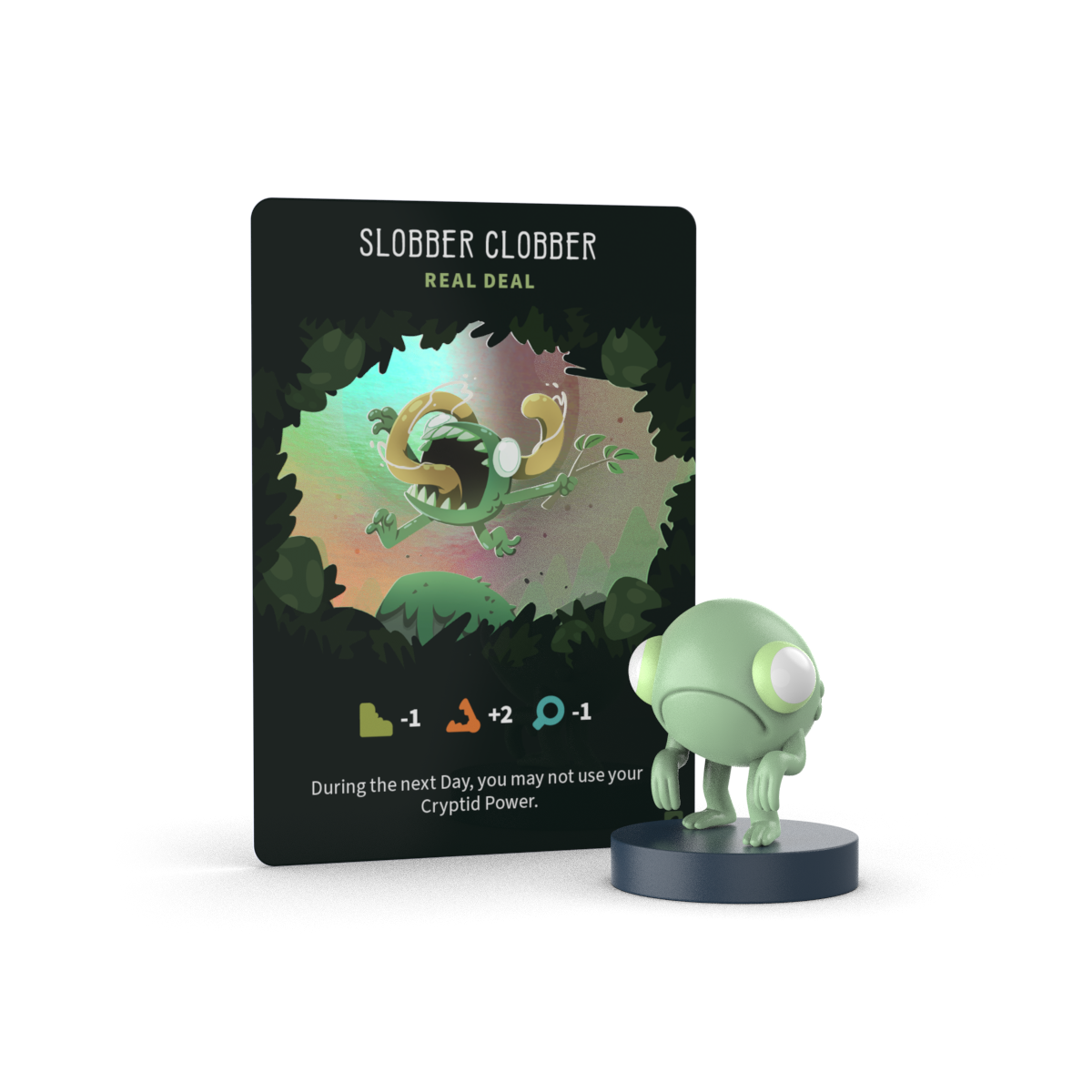 A game card labeled “Slobber Clobber” stands behind a small green creature figurine from the Unstable Games Twisted Cryptids: Vinyl Figure Blind Box; the card shows stats and abilities in symbols and text.