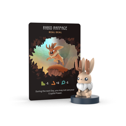 A "Rabid Rampage" game card with stats and effects is displayed next to a small brown and cream rabbit vinyl mini figure from Unstable Games' Twisted Cryptids: Vinyl Figure Blind Box, shown on a round base.
