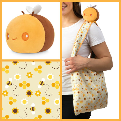 A woman is holding a Plushiverse Honeybee Plushie Tote Bag from TeeTurtle, showcasing her love for TeeTurtle plushies.