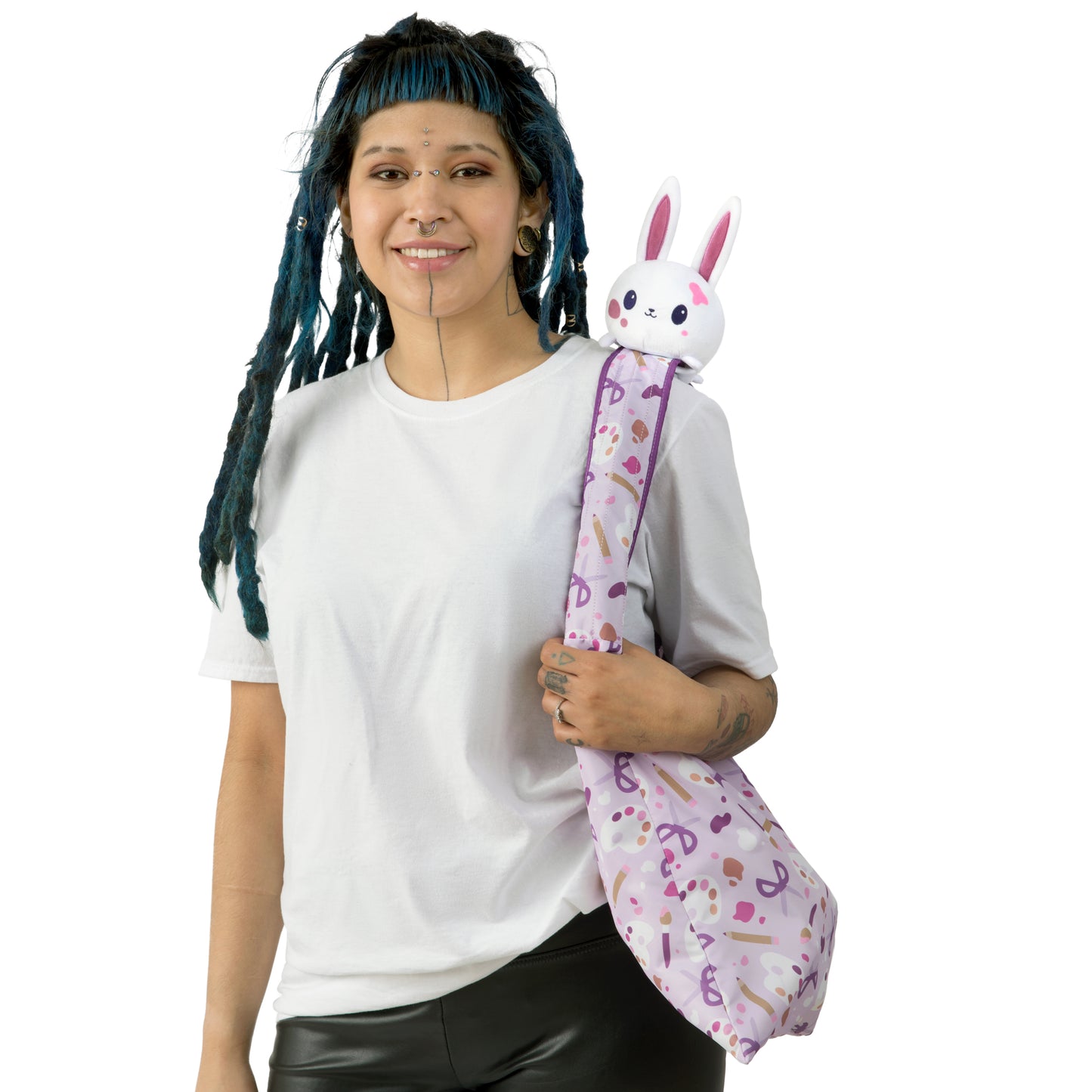 A woman with dreadlocks holding a TeeTurtle Plushiverse Arts & Crafts Bunny Plushie Tote Bag.