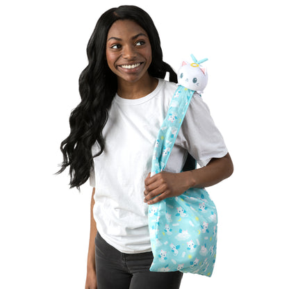 A young woman holding a secret Plushiverse Angelic Kitty Plushie Tote Bag containing a TeeTurtle plushie unicorn.