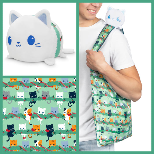 A man is holding a TeeTurtle Plushiverse Meowy Christmas Plushie Tote Bag with a cat on it.
