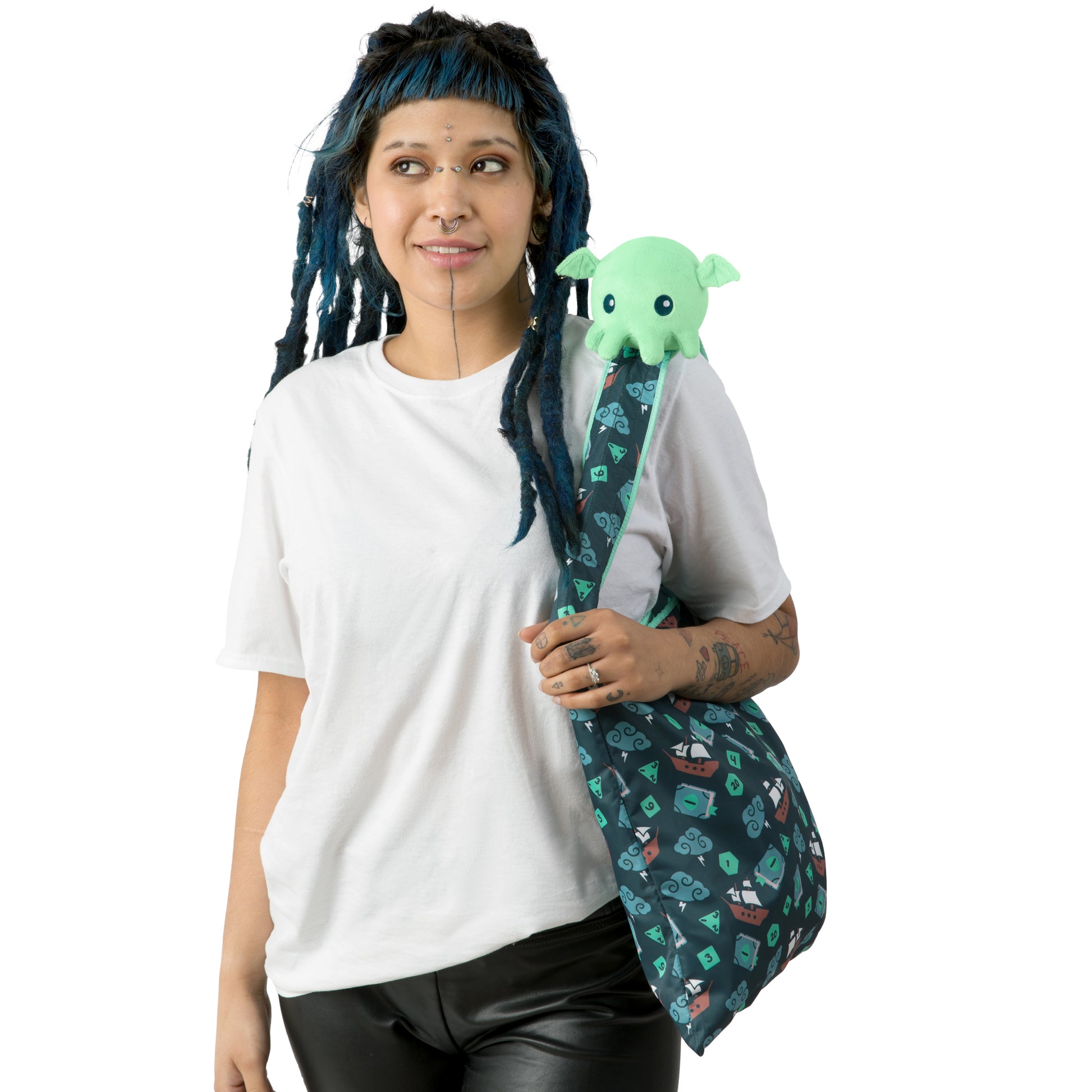 A woman holding a TeeTurtle Plushiverse Tabletop Cthulhu Plushie Tote Bag with an octopus printed on it.