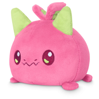 A TeeTurtle Plushiverse Dragon Fruit plushie with green eyes, perfect for storing in a tote bag.