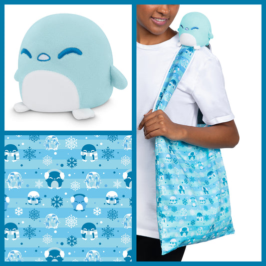 A woman is holding a Plushiverse Snowy Penguin Plushie Tote Bag by TeeTurtle.