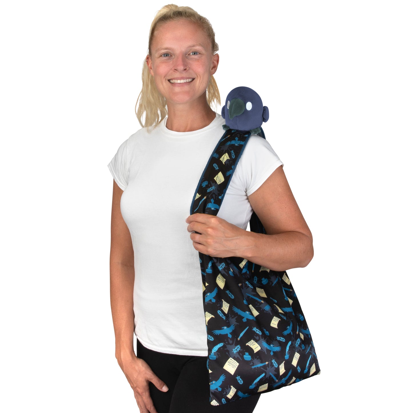 A woman carrying a secret Plushiverse Quill of the Raven Plushie Tote Bag containing a TeeTurtle plushie.
