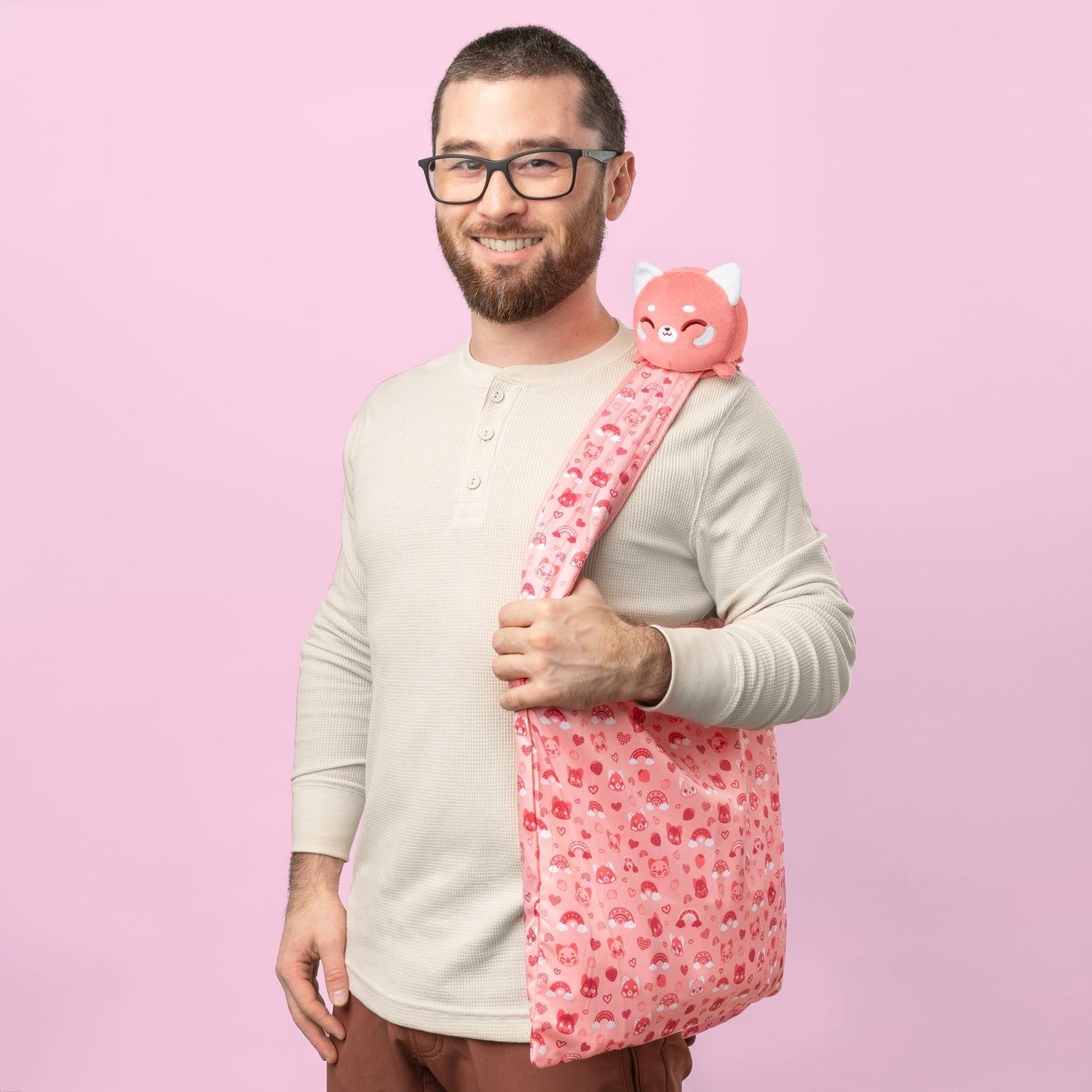 A man carrying a Plushiverse Lovable Red Panda Plushie Tote Bag from TeeTurtle.