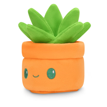 A Plushiverse Succulent Garden Plushie Tote Bag friend with green eyes in a pot, accompanied by a secret TeeTurtle tote bag.