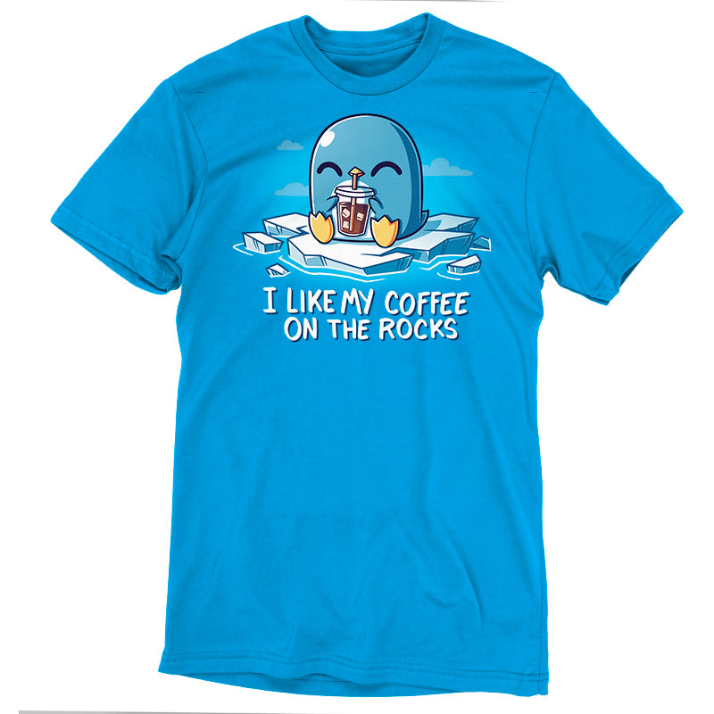 A cobalt blue T-shirt featuring a cartoon penguin drinking iced coffee and the text "I like my coffee on the rocks," made from super soft ringspun cotton. Product Name: I Like My Coffee on the Rocks Brand Name: monsterdigital