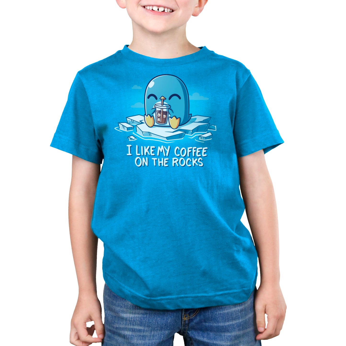 A child wearing a super soft ringspun cotton T-shirt in cobalt blue, adorned with a cartoon penguin sipping iced coffee and the text "I LIKE MY COFFEE ON THE ROCKS" from monsterdigital’s I Like My Coffee on the Rocks collection.