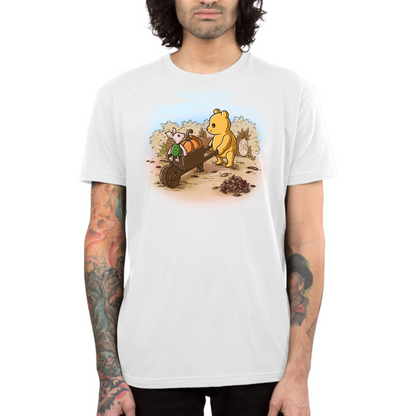 Premium Cotton T-shirt_TeeTurtle white A Perfect Autumn Day Premium Cotton T-shirt featuring a bear pulling a wagon filled with pumpkins while a little mouse rides along, surrounded by autumn bushes, fallen leaves, and tree stumps on a crisp fall day.