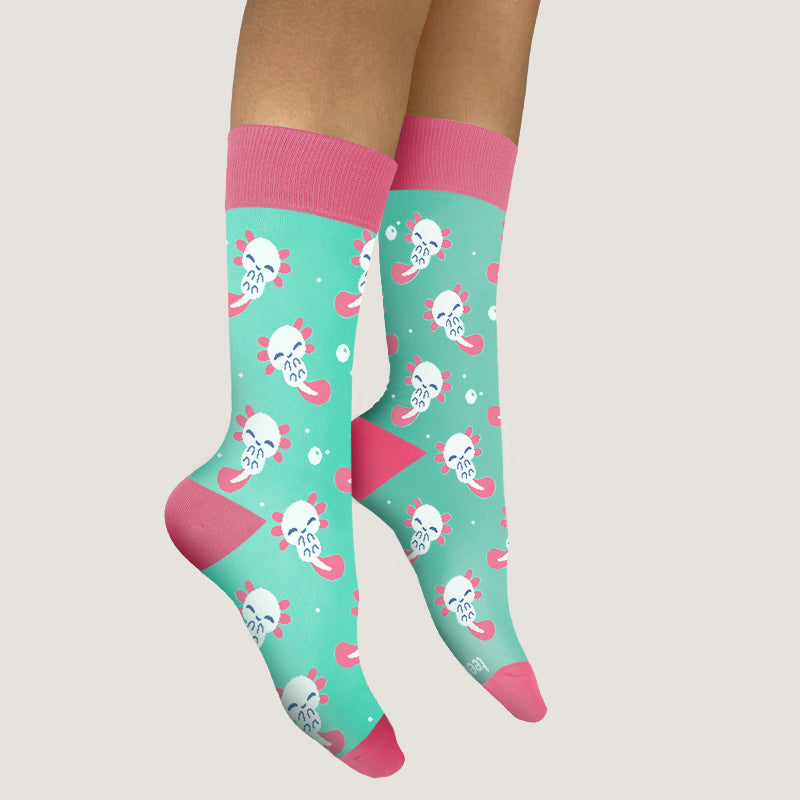A woman enjoying the comfortable fit of her TeeTurtle Axolotl Pattern Socks adorned with pink and green skulls.