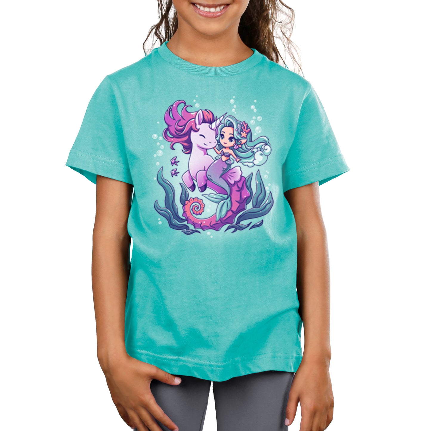 A girl wearing a turquoise TeeTurtle t-shirt with the BFFs (Sea Unicorn and Mermaid) on it, ready for an undersea adventure.