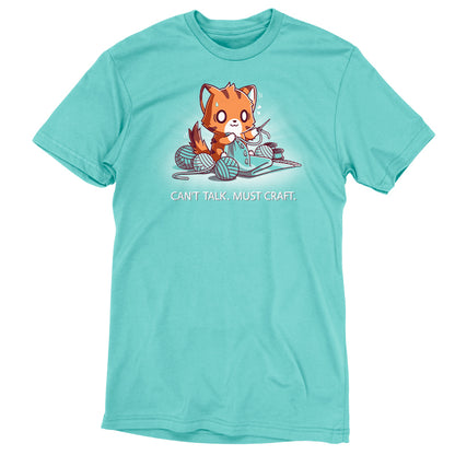 A Caribbean blue T-shirt featuring an illustration of a fox knitting with multiple balls of yarn and the text "Can't Talk. Must Craft." Made from super soft ringspun cotton, this Can’t Talk. Must Craft shirt by monsterdigital ensures comfort while you channel your inner crafter.