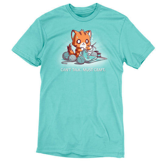 A Caribbean blue T-shirt featuring an illustration of a fox knitting with multiple balls of yarn and the text 