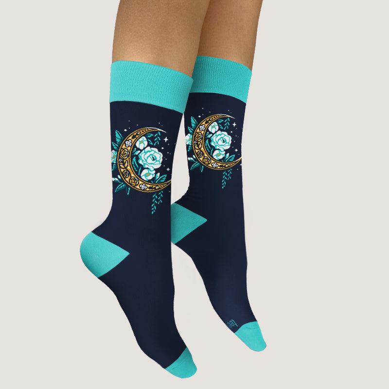 A woman enjoying the comfort of her Floral Moon Socks adorned with a moon and flowers design by TeeTurtle.