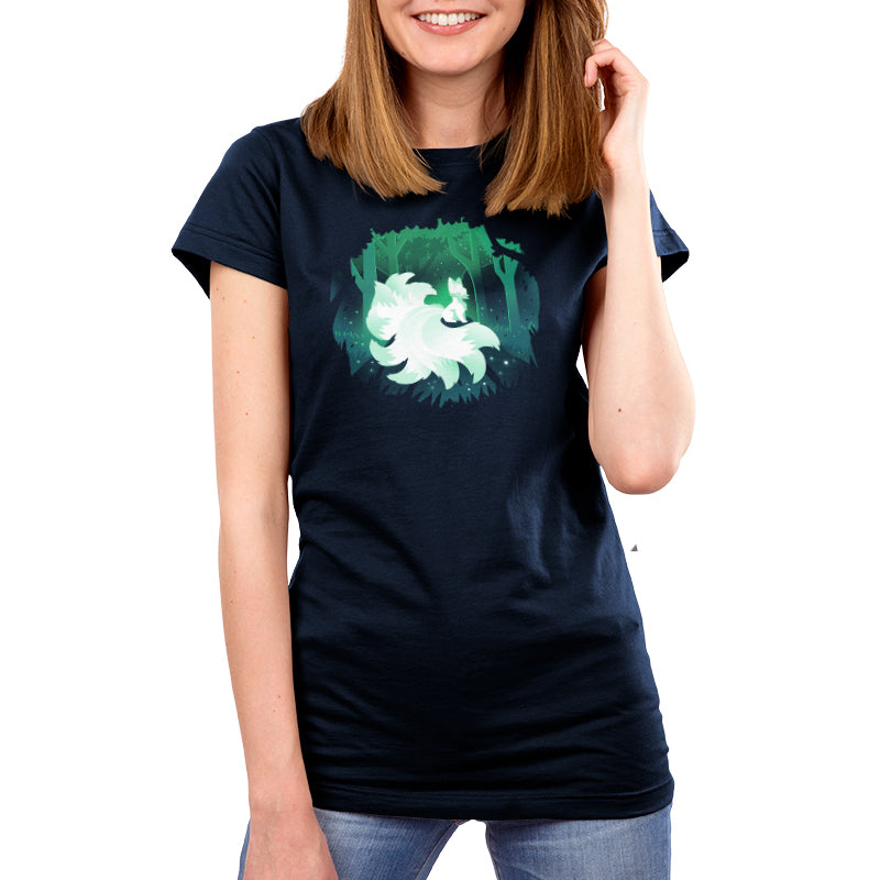 A woman wearing a navy blue Forest Kitsune t-shirt with an image of a tree in an enchanted forest.