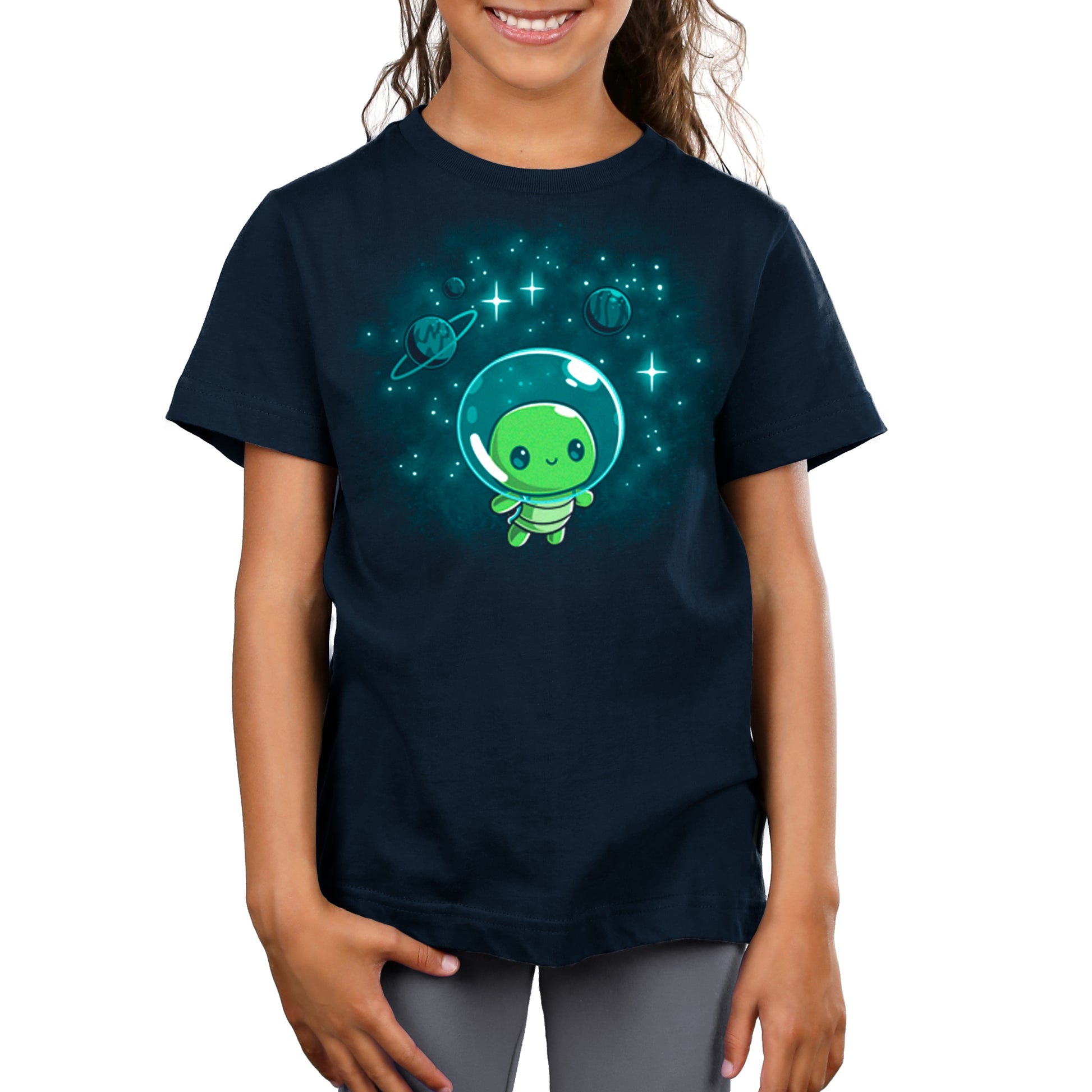 A girl wearing a TeeTurtle Galactic Turtle t-shirt with a green alien in space.