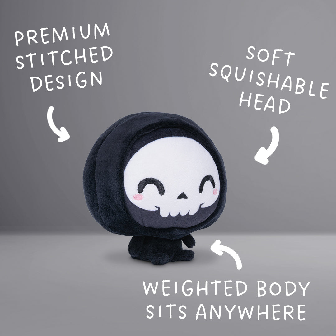 Cloudheads: 5" Grim Reaper (Grim) - A black hooded plush grim reaper with a white skull face, black embroidered eyes and mouth, and small pink cheeks, shown on a plain white background. Text with the phrases "Premium stitched design," "soft squishable head" and "weighted body sits anywhere."