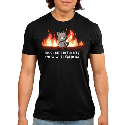 Men's Premium T-Shirt_TeeTurtle black I Definitely Know What I'm Doing Men's Premium T-Shirt featuring a smug gray cat standing confidently in front of bright flames with the text "Trust Me, I Definitely Know What I'm Doing."