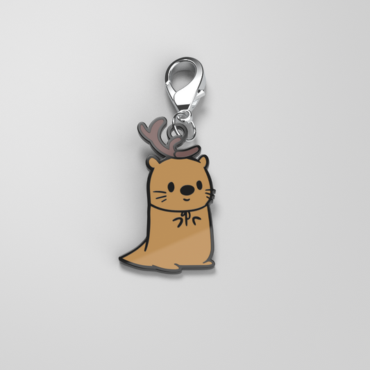 A brown cat charm with antlers on it, perfect as an All of the Otter Reindeer Enamel Keychain by TeeTurtle for your metal keys.
