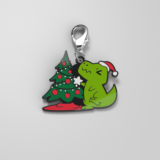 A TeeTurtle Christmas T-Rex enamel keychain with a Christmas tree charm.