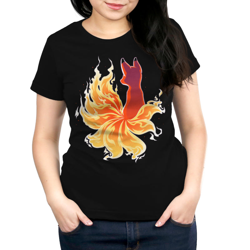 Person wearing a black monsterdigital Fire Kitsune t-shirt made of super soft ringspun cotton, featuring a colorful graphic of a fire kitsune surrounded by flames, standing with hands in pockets.