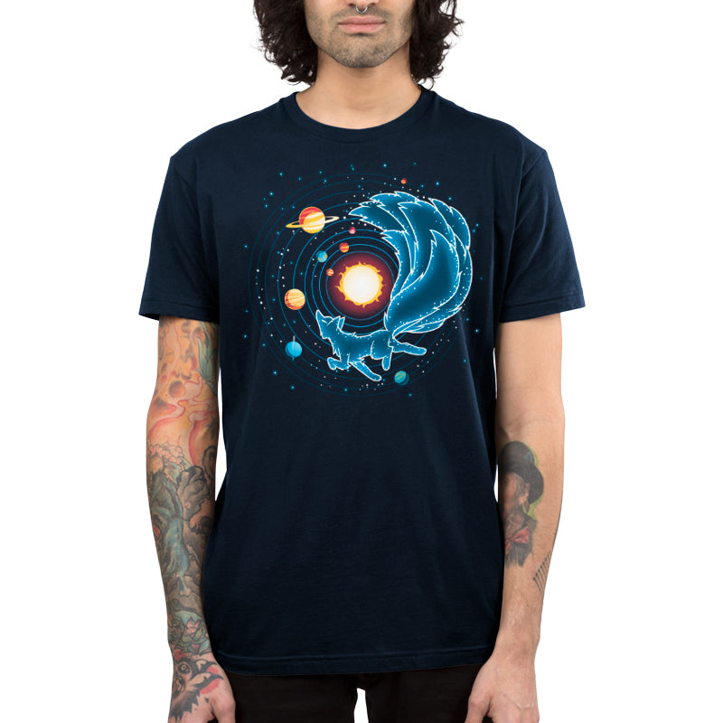 A person with curly hair wears a navy blue t-shirt made of super soft ringspun cotton, featuring a monsterdigital Kitsune Constellation design with a fox and planets. Their arms display colorful tattoos.