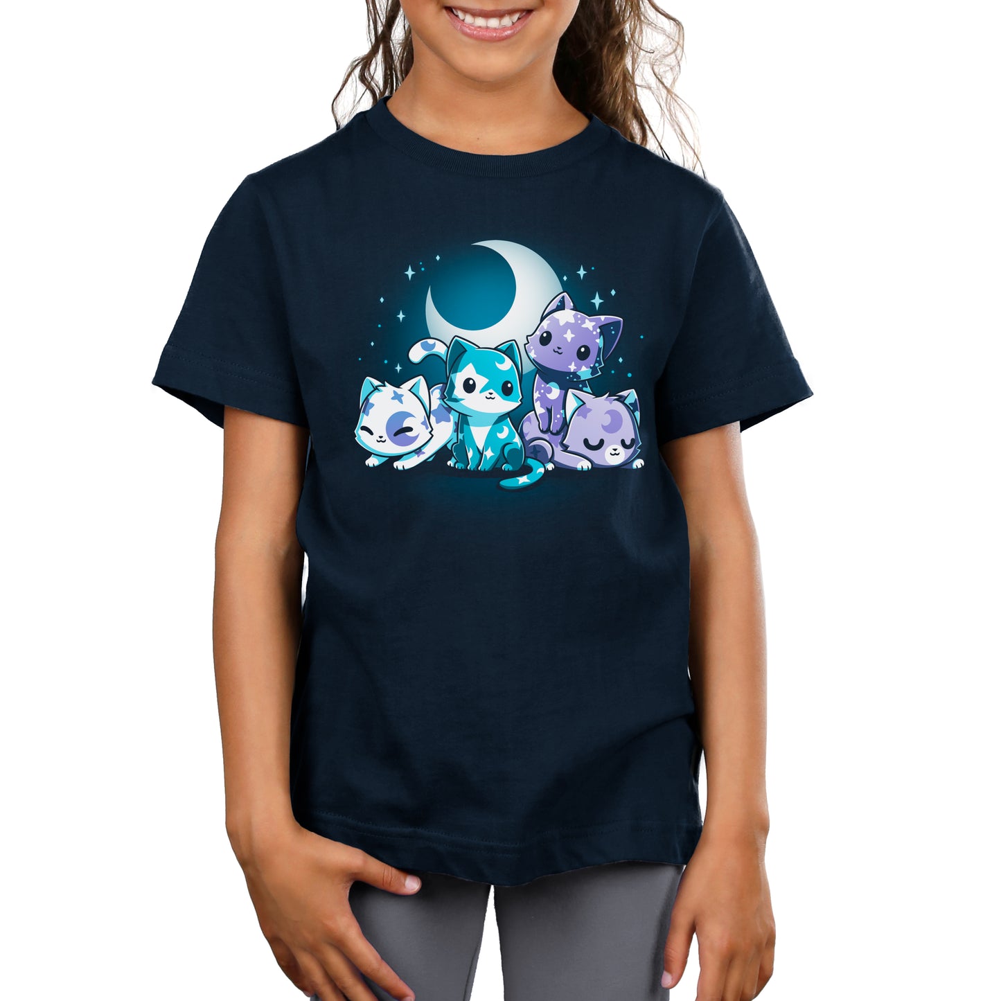A child is wearing a super soft ringspun cotton navy blue Moon & Star Meows t-shirt by monsterdigital, featuring an illustration of four stargazing companions: one sitting, one standing, and two lying down under a crescent moon and stars.
