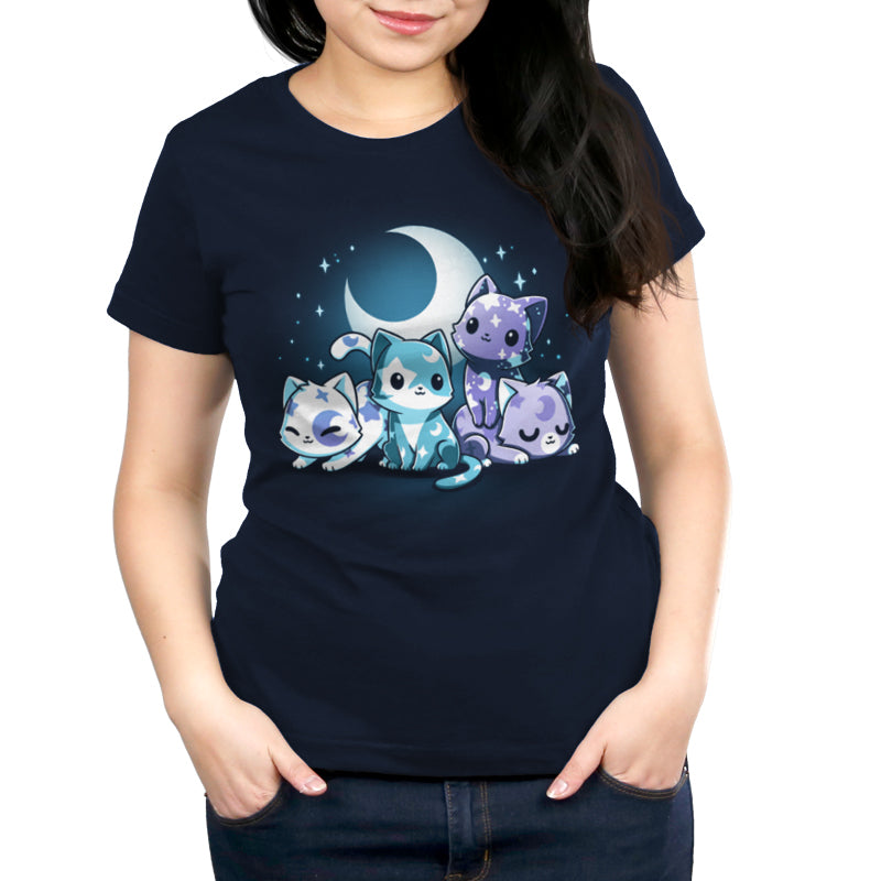 A woman wearing a navy blue Moon & Star Meows T-shirt by monsterdigital, made of super soft ringspun cotton, featuring an illustration of three cartoon cats as stargazing companions with the moon and stars.
