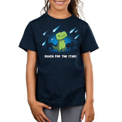 A child wearing a navy blue monsterdigital tee with a green dinosaur graphic and the text "Reach for the Stars" enjoys the comfort of super soft ringspun cotton.