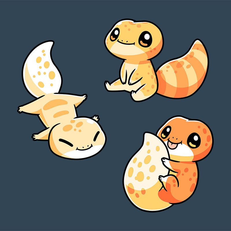 Three cute, cartoon-style Lil' Geckos with varying yellow and orange patterns, sitting and lying on a dark blue background of a Super Soft Ringspun Cotton Denim Blue T-Shirt by monsterdigital.