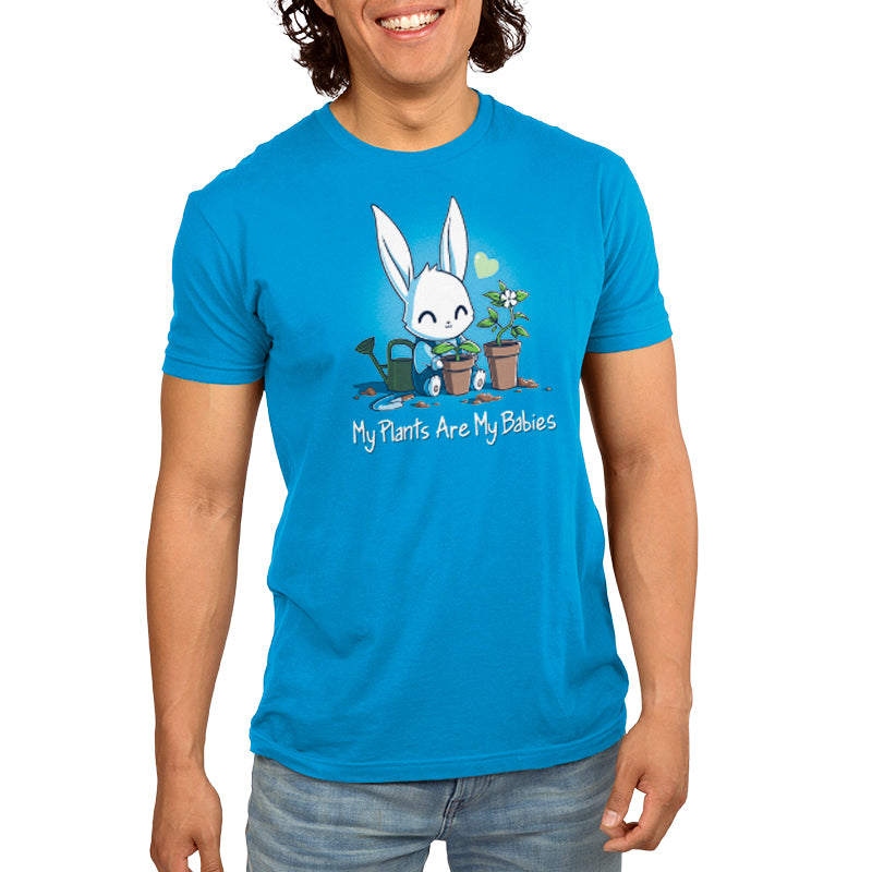 A young man wearing a blue t-shirt with a rabbit on it by TeeTurtle featuring the product "My Plants Are My Babies