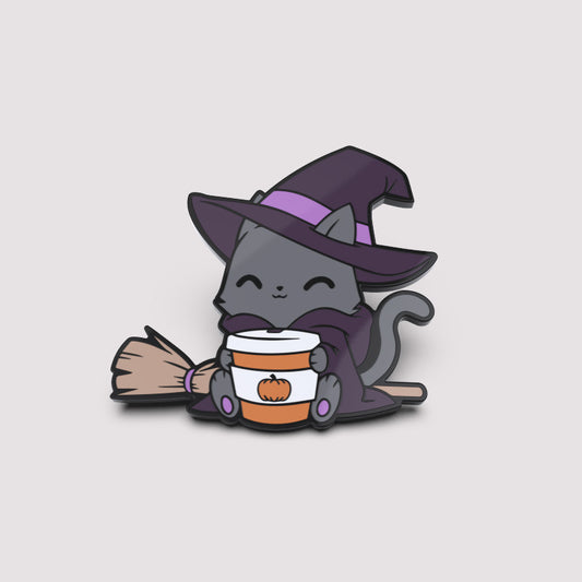 A cat in a witch hat holding a broom and wearing the TeeTurtle Basic Witch Pin.
