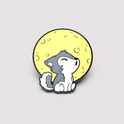 A cute TeeTurtle enamel pin featuring the Lil' Werewolf Pin (Glow) sitting in front of the moon.