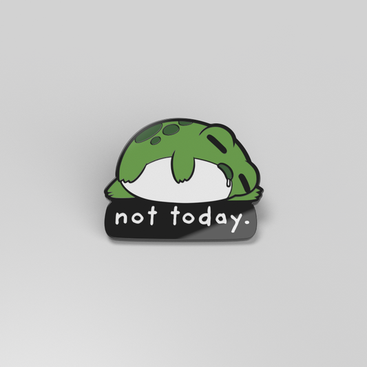A green frog enamel pin with the words 
