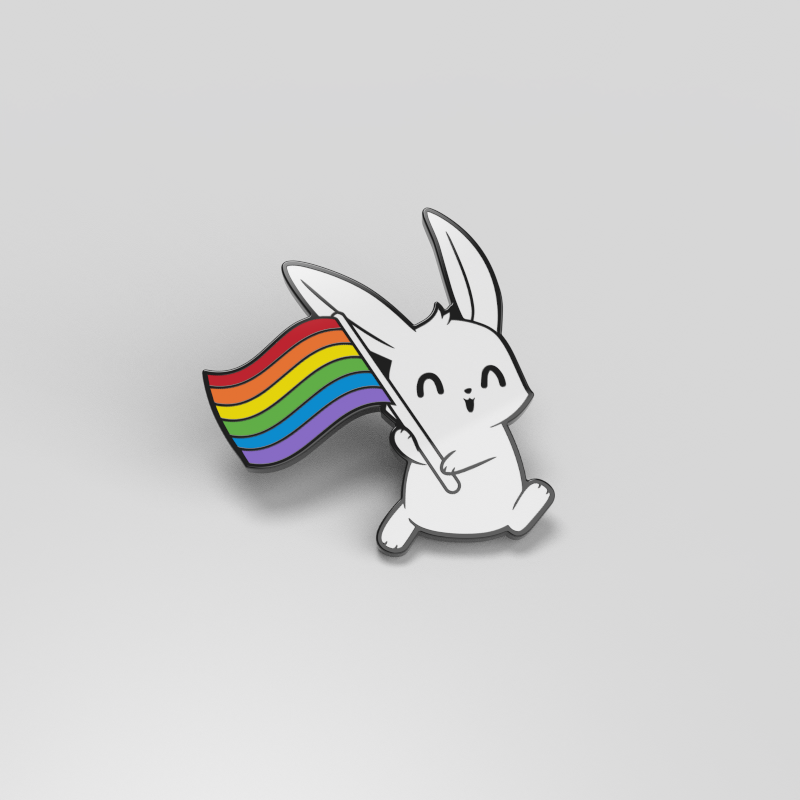 A white Pride Bunny Pin holding a rainbow flag. The Pride Bunny Pin is represented by an enamel pin of small dimensions from TeeTurtle.