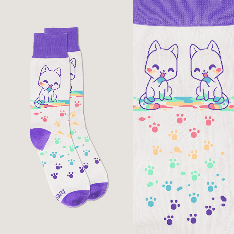 A pair of Rainbow Paw Print Socks by TeeTurtle with cats and paw prints on them.