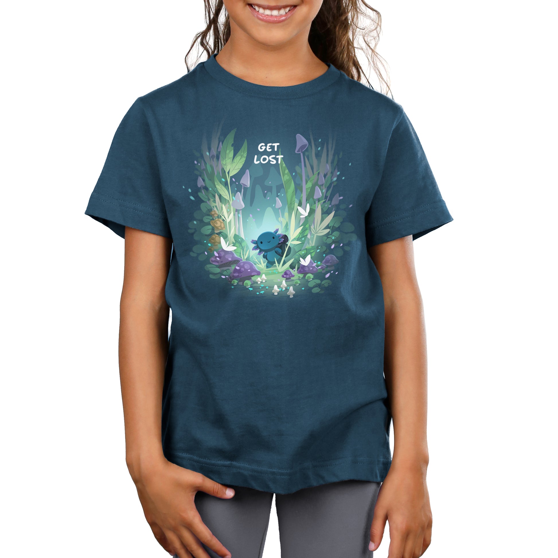 Young girl smiling, wearing a MonsterDigital Axolotl Explorer t-shirt with a whimsical forest design and the phrase "get lost" printed on it.