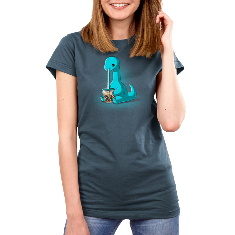 A woman wearing a blue t-shirt with an image of a dinosaur enjoys her TeeTurtle Boba Dinosaur with an extra long reusable straw.